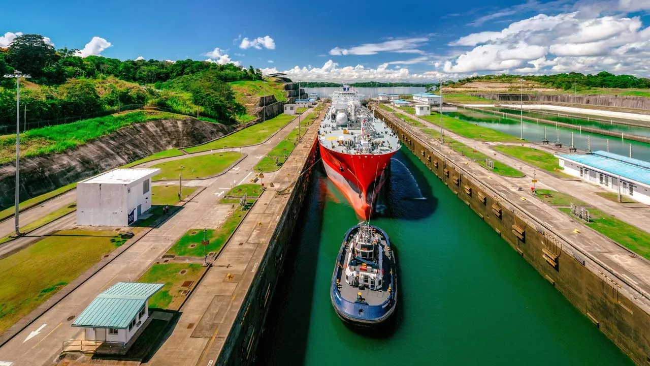 Buque cruzando una esclusa del Canal de Panamá, asistido por un remolcador
